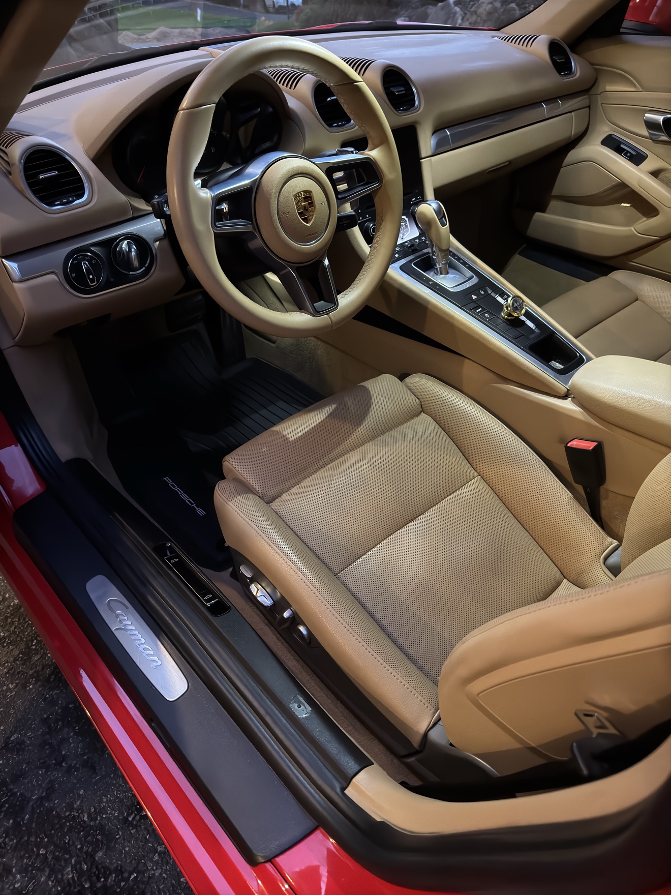 Porsche 718 Cayman driver interior with tan leather seats and Cayman sill plate