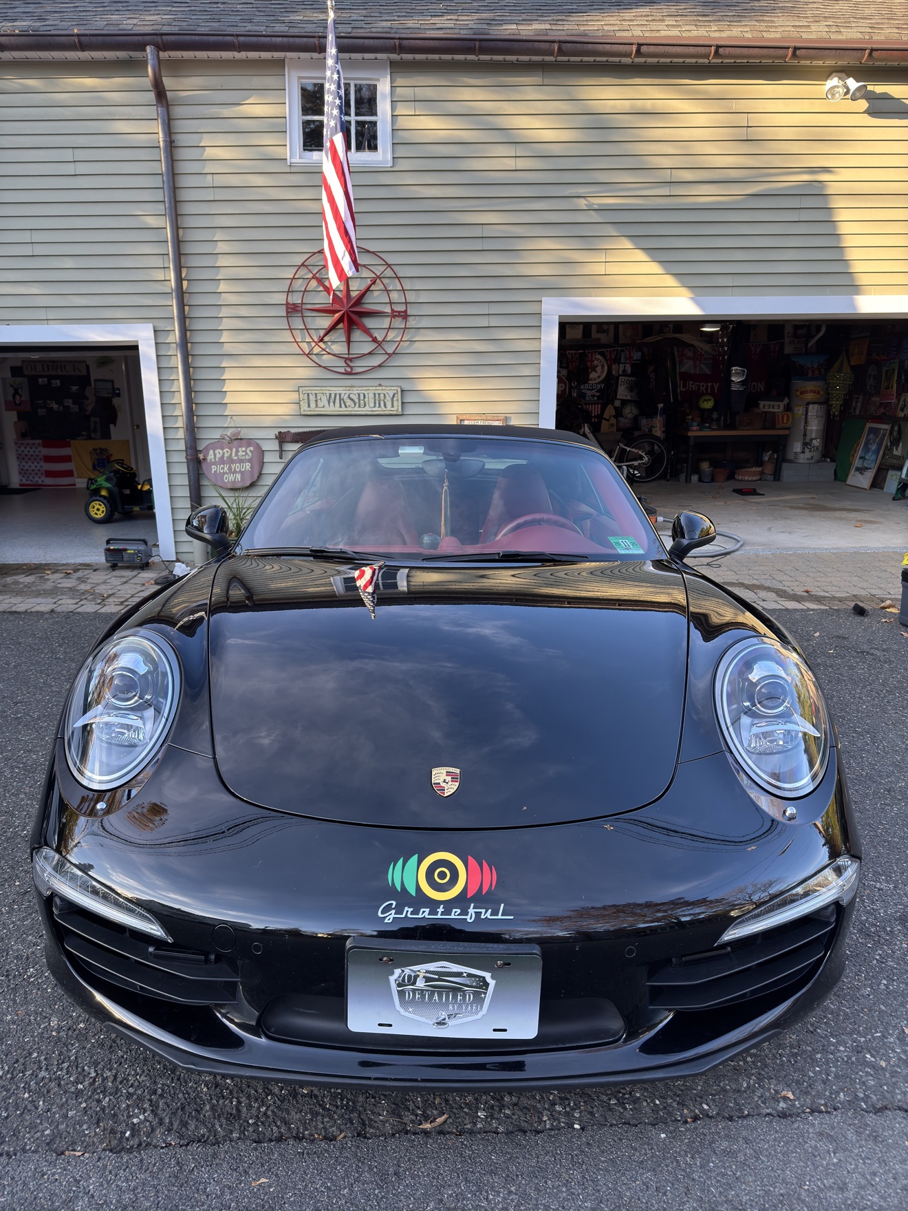 Black Porsche 911 Carrera S convertible front view with Grateful hood decal
