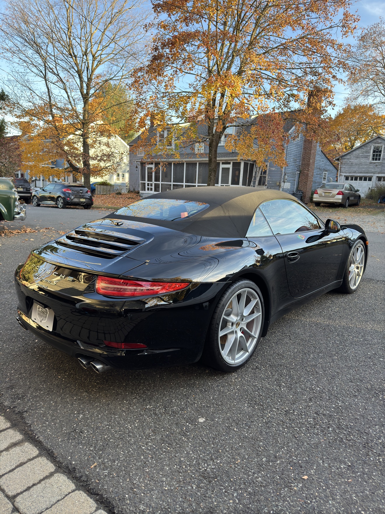 Black Porsche 911 Carrera S convertible rear angle view after detailing