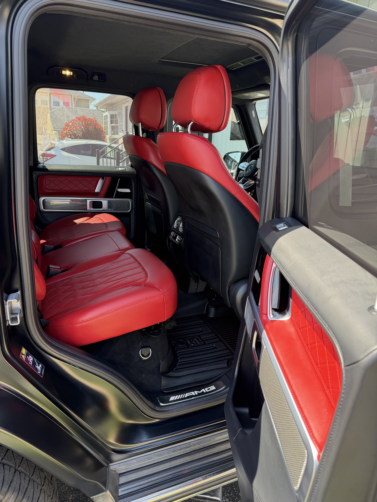 Rear cabin of the Mercedes-AMG G 63 with red leather seats and AMG door sill
