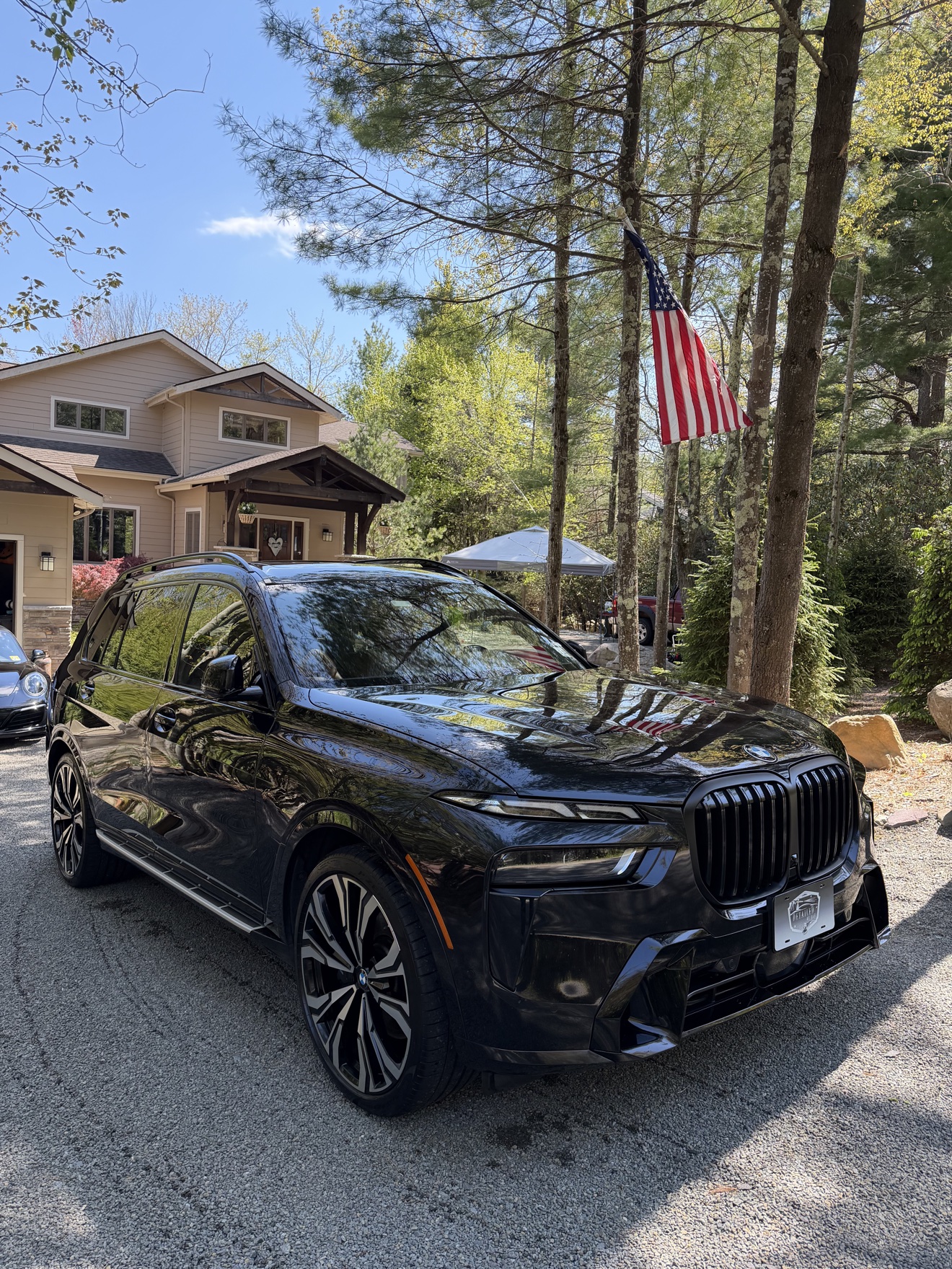 Black BMW X7 front three-quarter view in a driveway after detailing