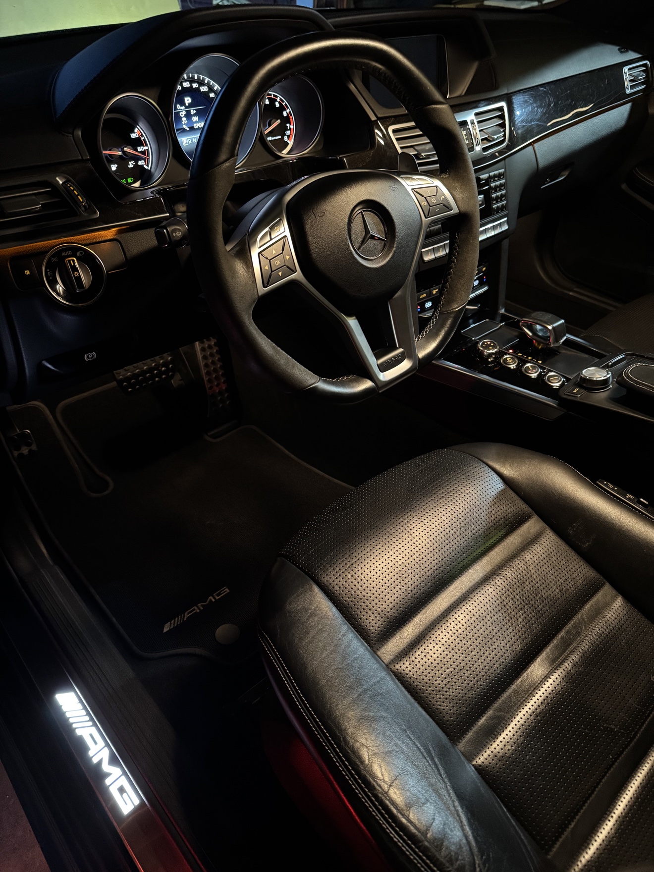 Mercedes Benz E63 S AMG driver cockpit with illuminated AMG door sill after detailing