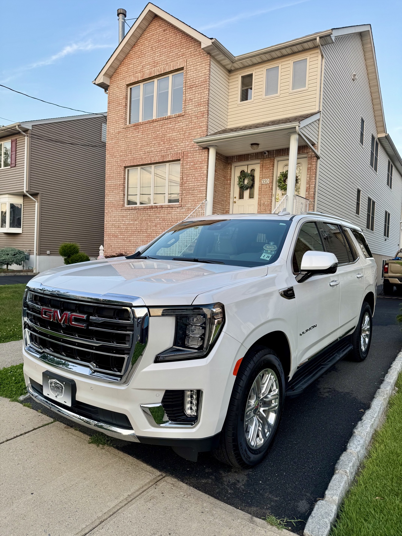 White GMC Yukon SLT front three-quarter view after detailing