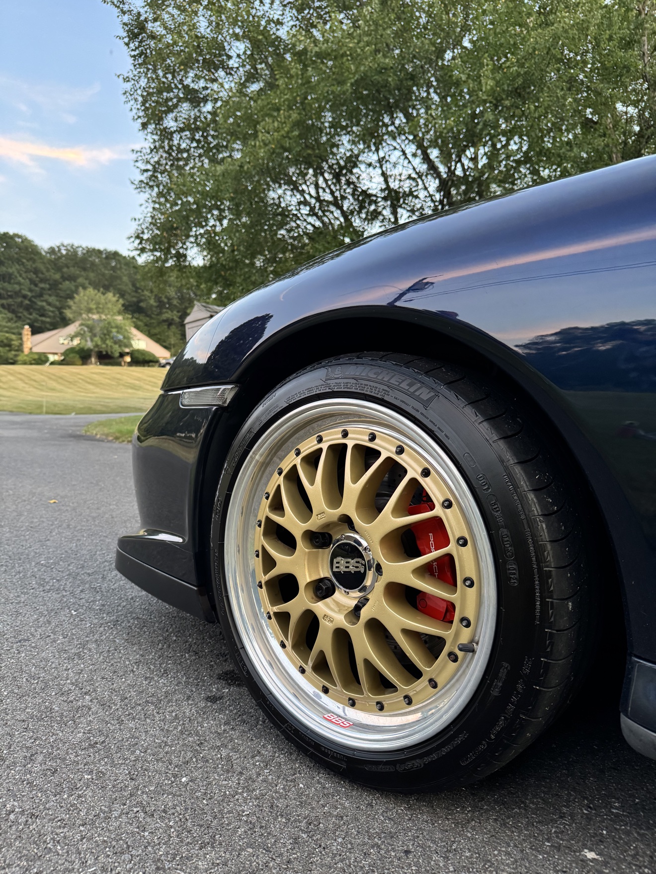 Black Porsche 911 Turbo front three-quarter view with gold BBS wheels after detailing
