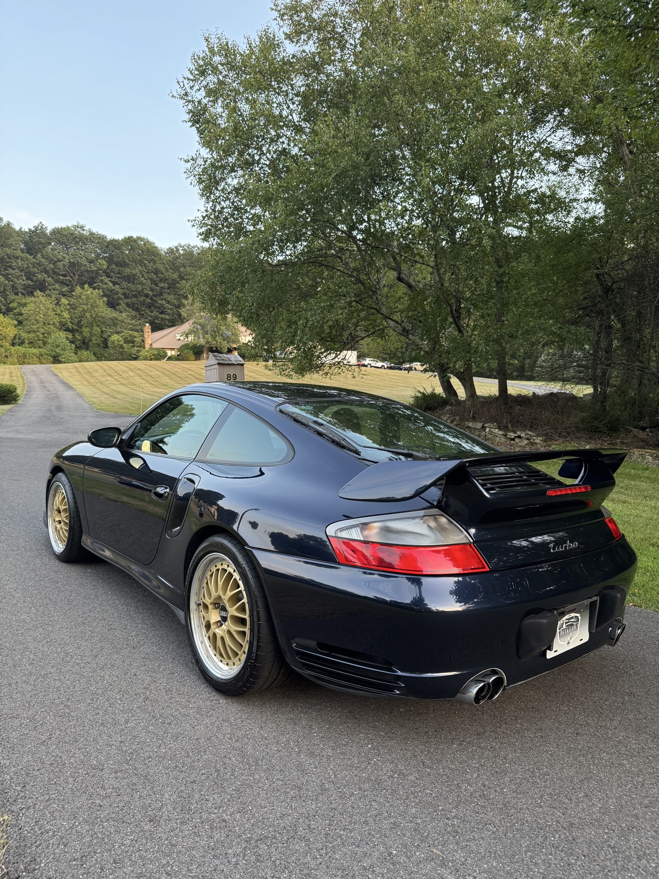 Black Porsche 911 Turbo rear angle view with gold BBS wheels after detailing