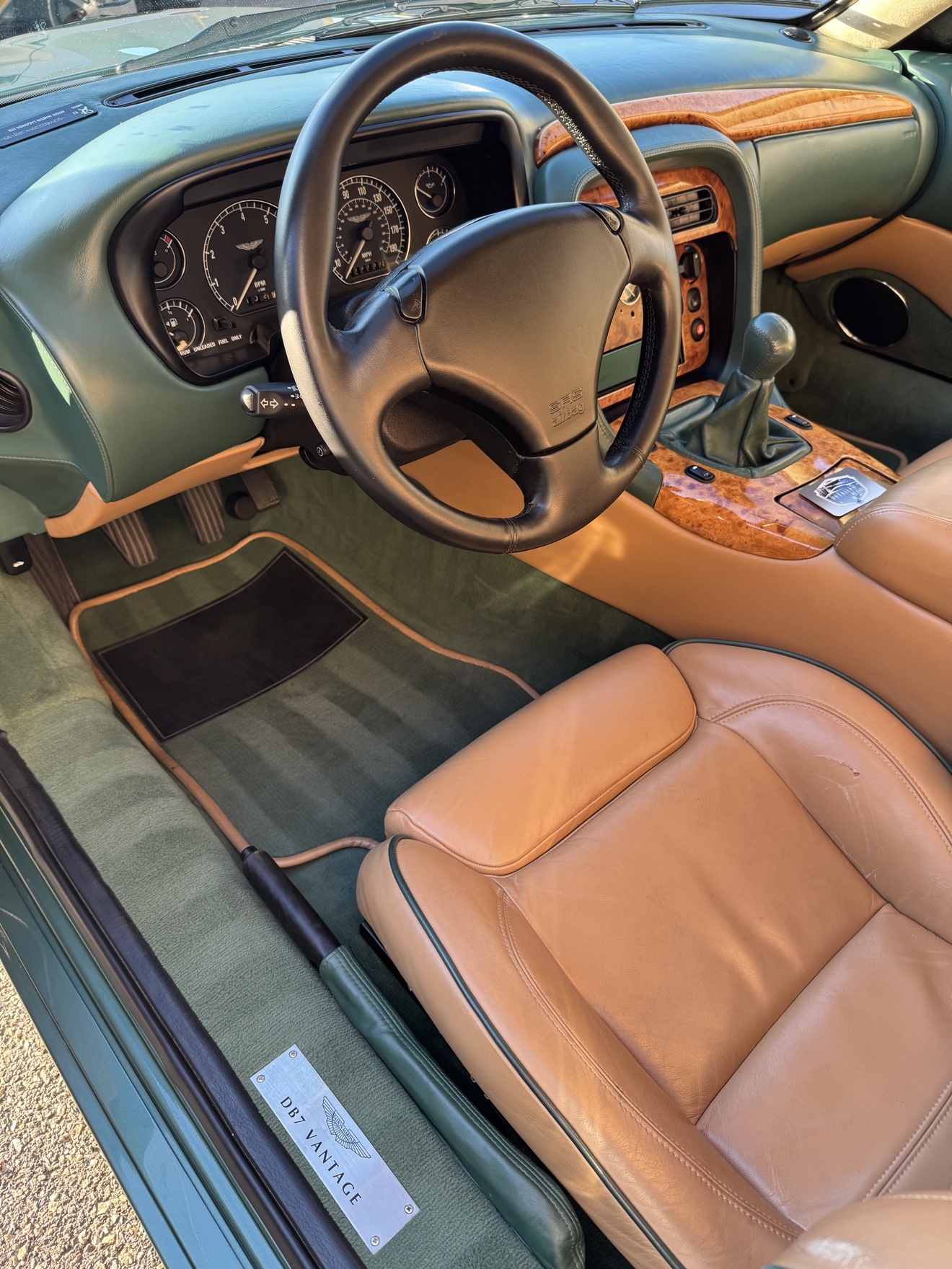 Aston Martin DB7 Vantage driver cockpit with tan leather seats, walnut trim and DB7 Vantage sill plate