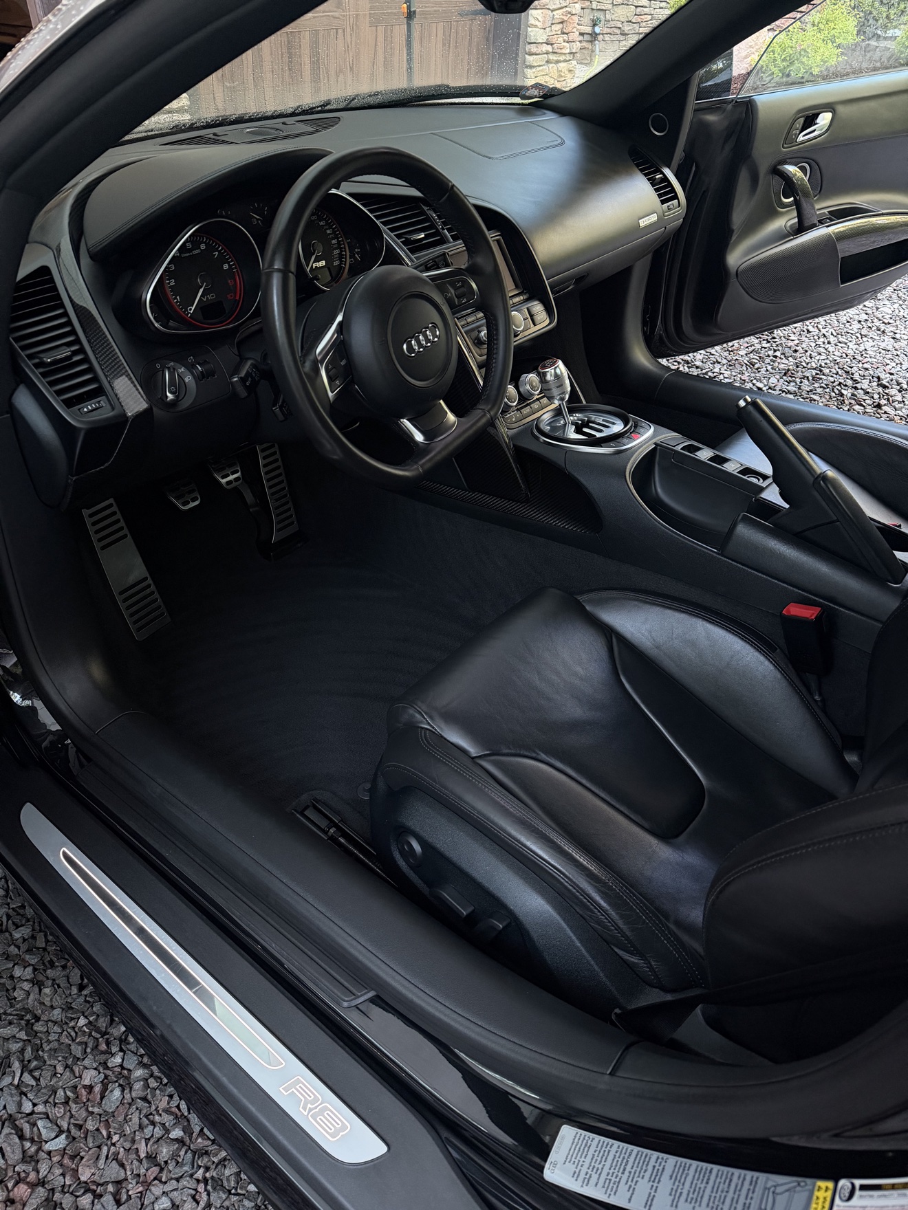 Audi R8 Spyder driver cockpit with black leather interior, gated manual shifter and R8 sill plate