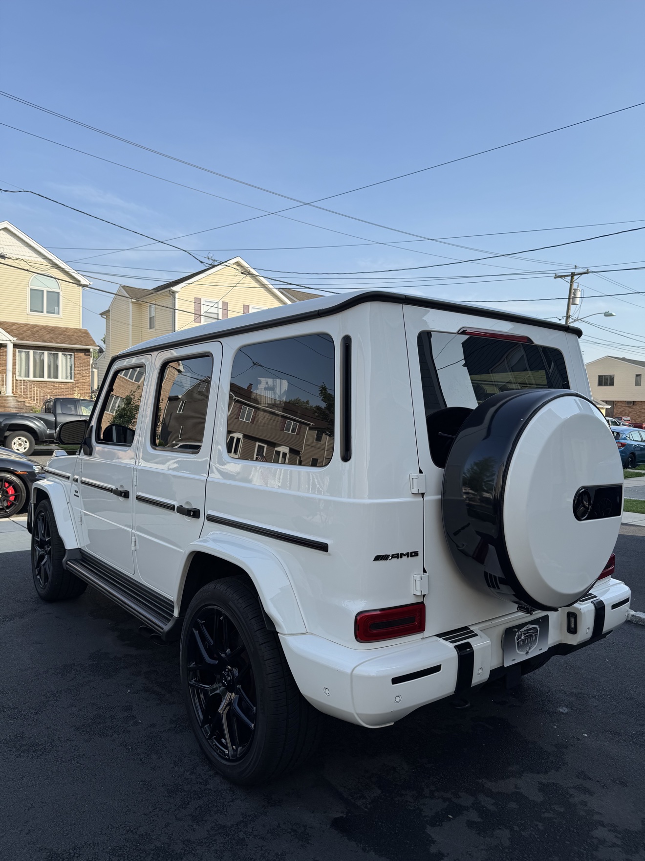 White Mercedes-AMG G 63 rear three-quarter view with Detailed by Yael plate frame