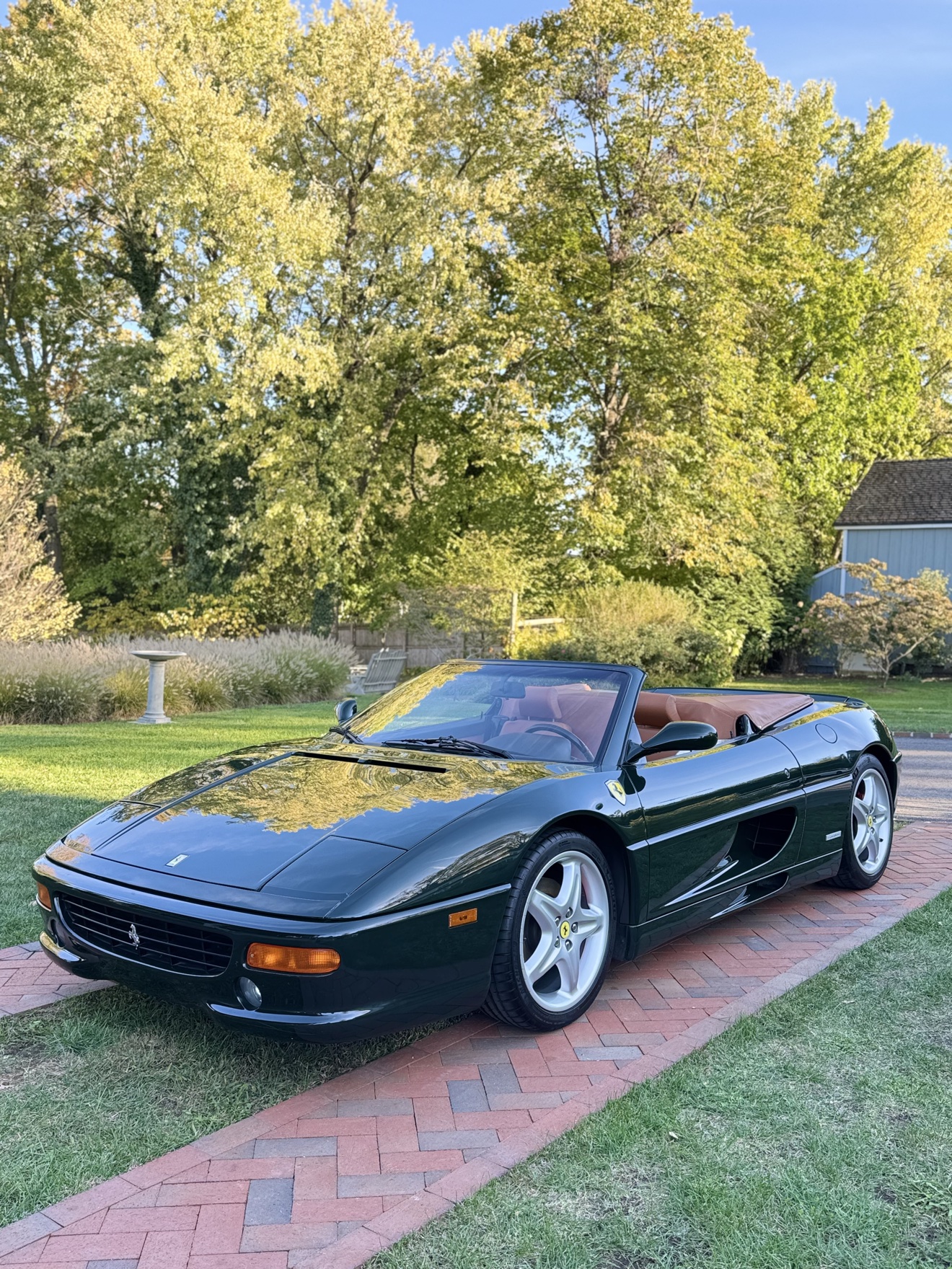 Dark green Ferrari F355 Spider front angle view on the lawn